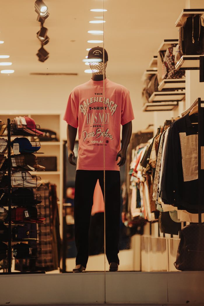 Services Elegant mannequin display in a clothing store featuring modern casual apparel, emphasizing a stylish pink graphic t-shirt.