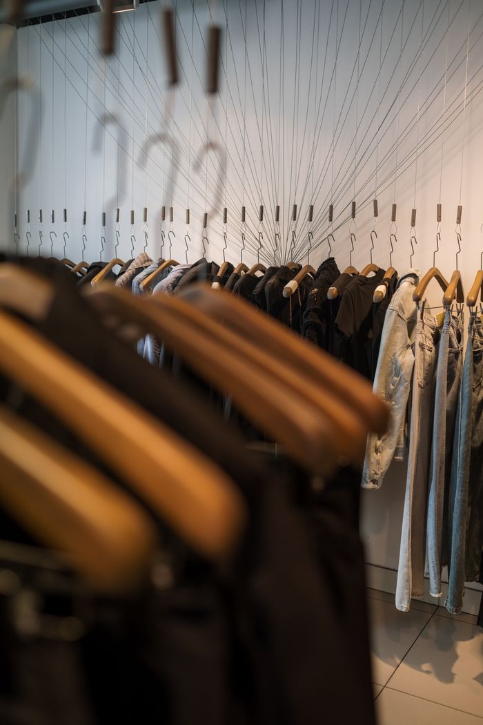 Services A trendy clothing rack with hanging garments in a fashion boutique, offering a sleek shopping experience.